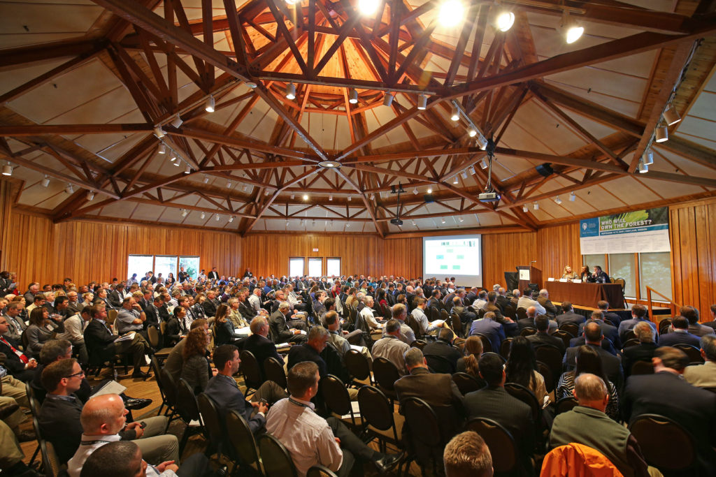 Crowded audience seated inside World Forestry Center for a presentation.