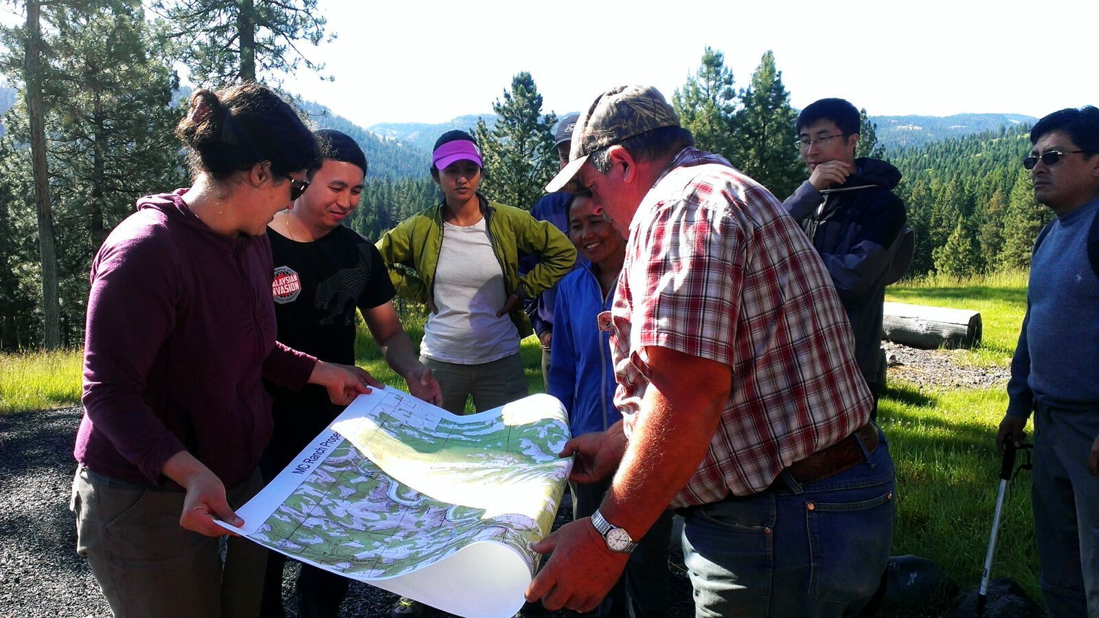 International Fellows examine a map on a trail