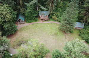 Aerial view of three cabins and field