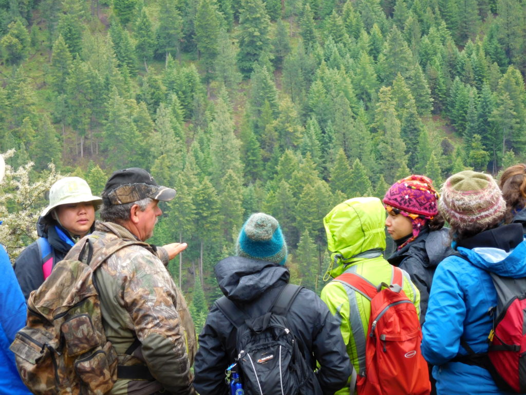 Group of people posing for a photo overlooking hillside of tree