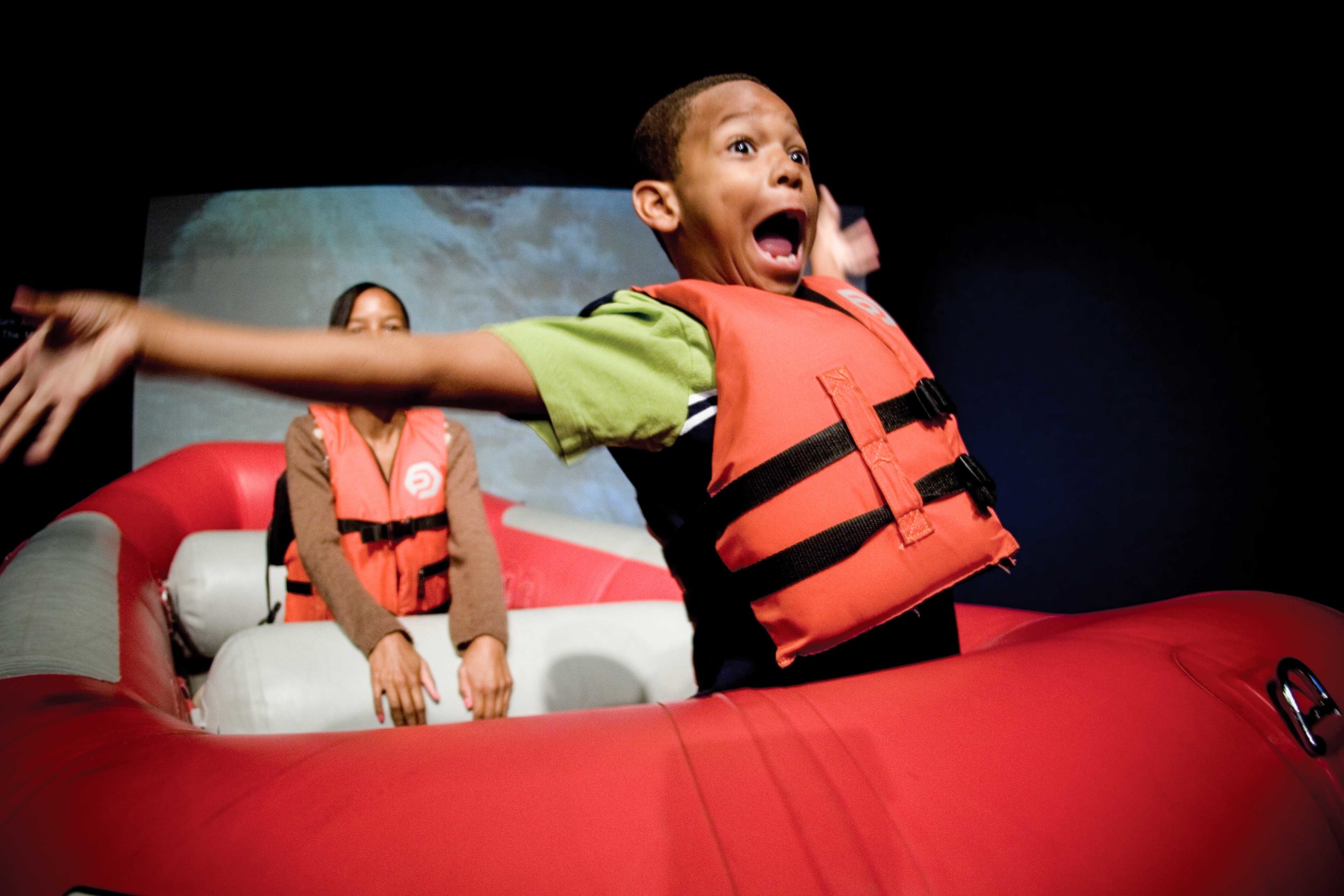 Excited young boy with life jacket on raft
