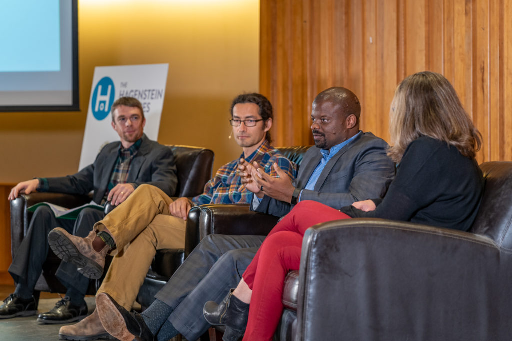 Panel of speakers presents on a stage