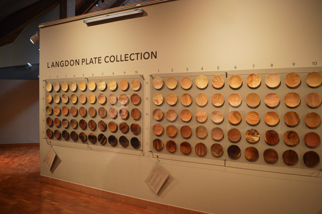 Some of the 150 wooden plates on a wall, showcasing the Langdon Plate Collection.