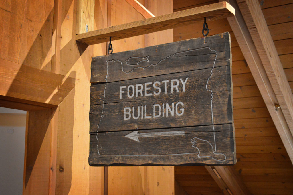 A wooden sign pointing to the "forestry building".