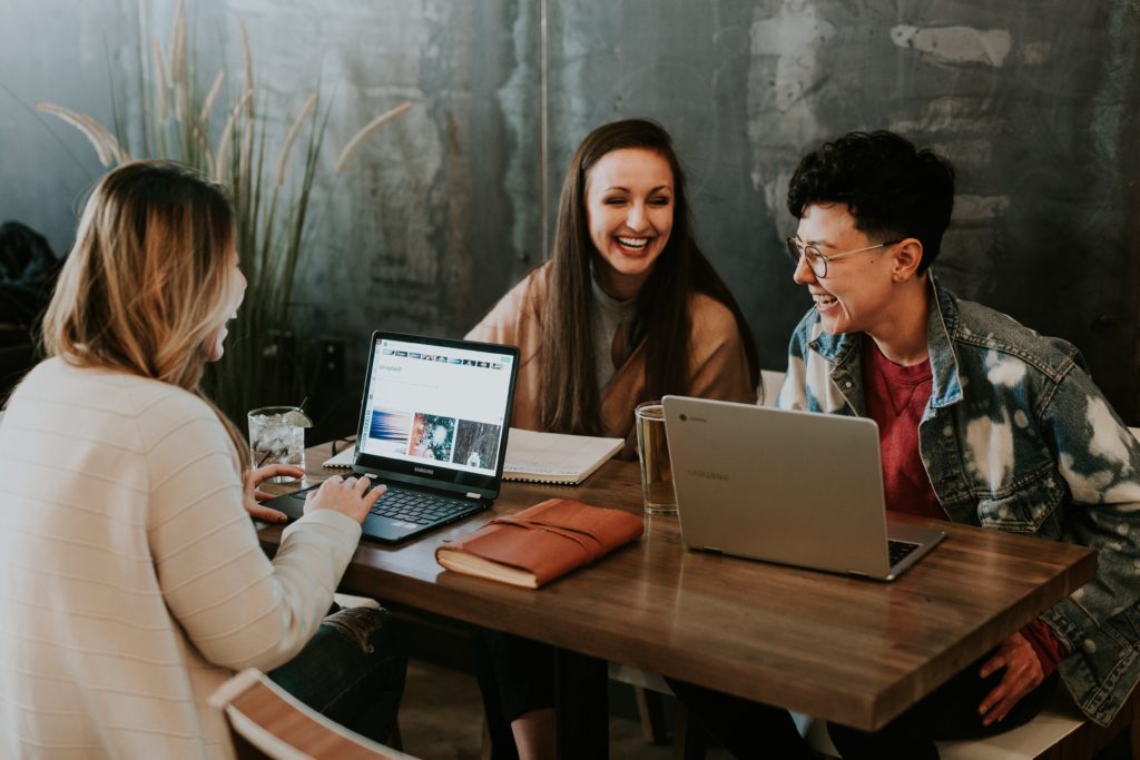 Three young professionals sitting around computers