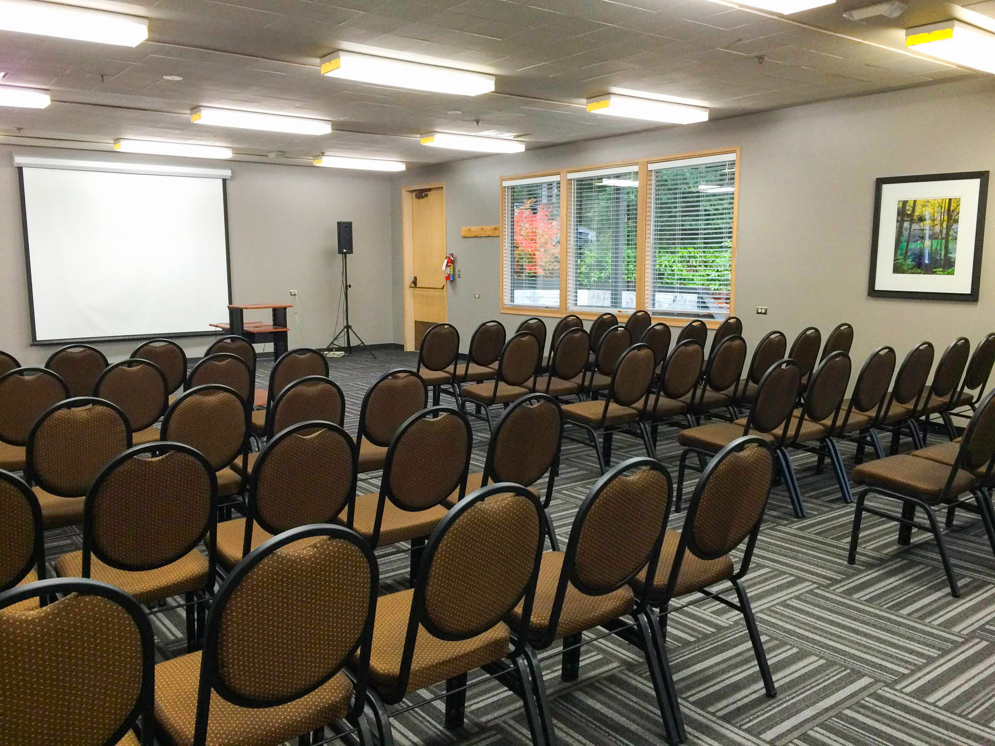 Conference room set up with chairs and projector screen