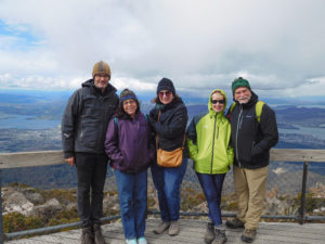 Five people posing for a photo over a vista