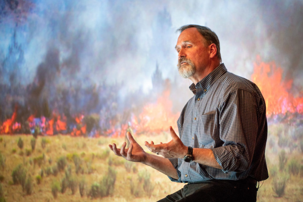 Man talking with forest fire background.