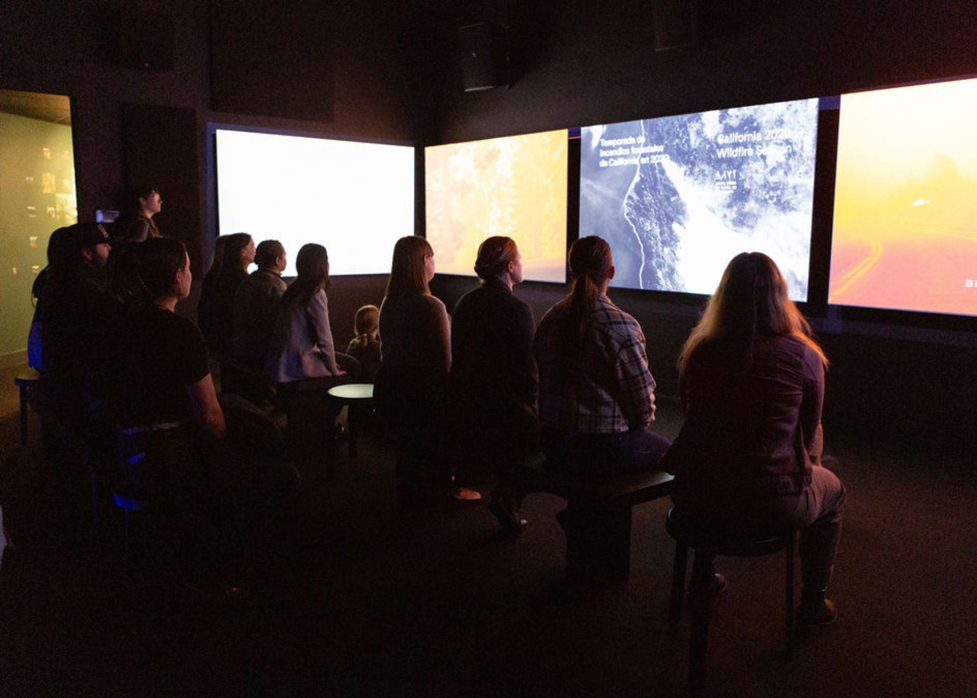 people_in_theater_looking_at_screens