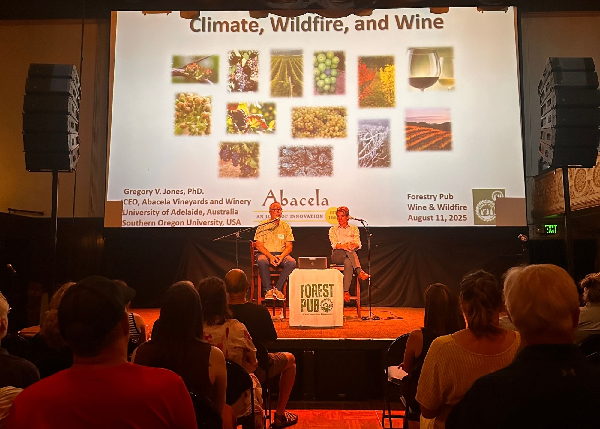 people_on_stage_with_screen_wine