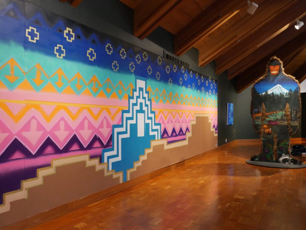 Colorful mural and Sasquatch exhibit installation inside museum gallery space